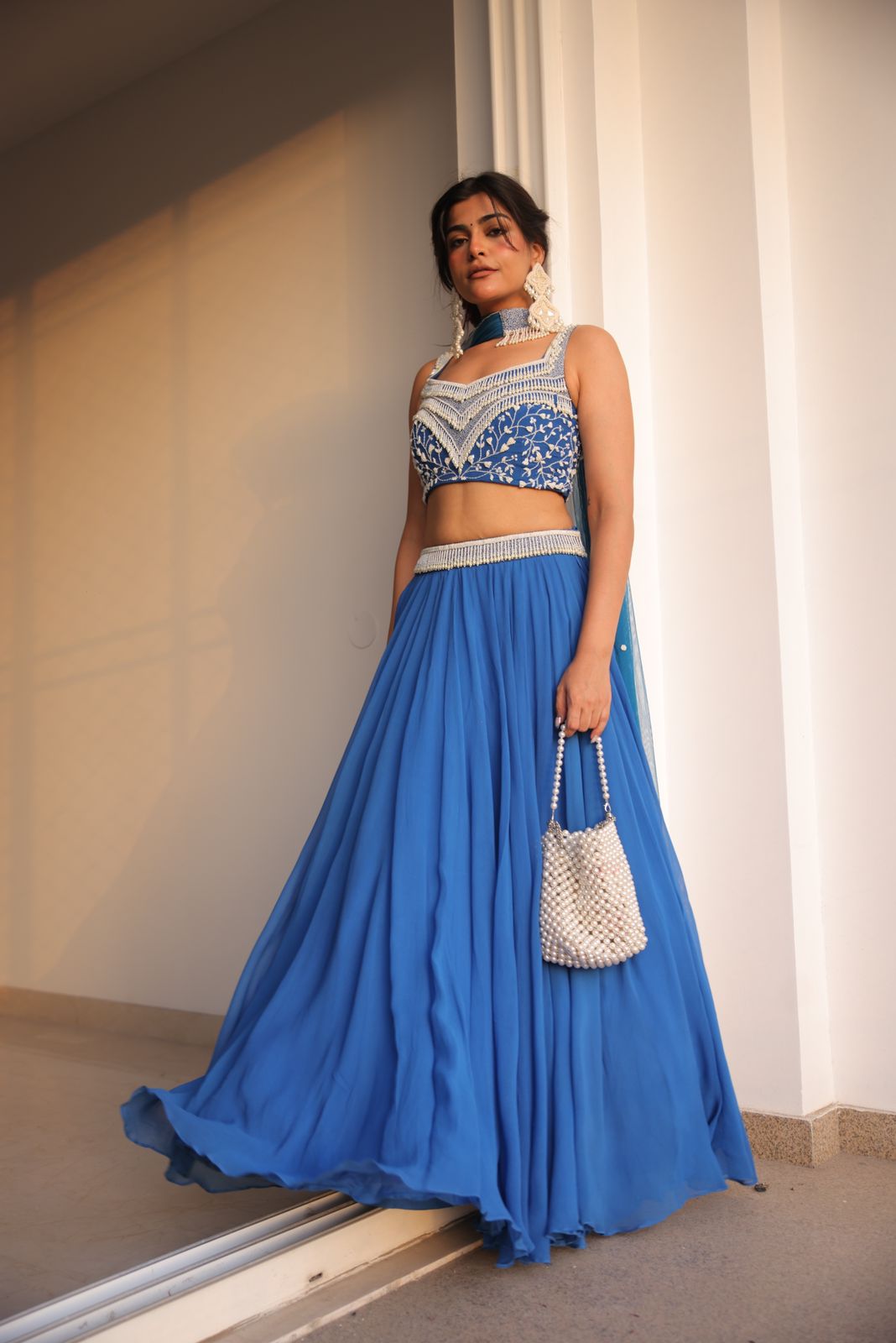 Kritika Khurana wearing a cobalt blue lehenga with pearl work and choker-style dupatta.