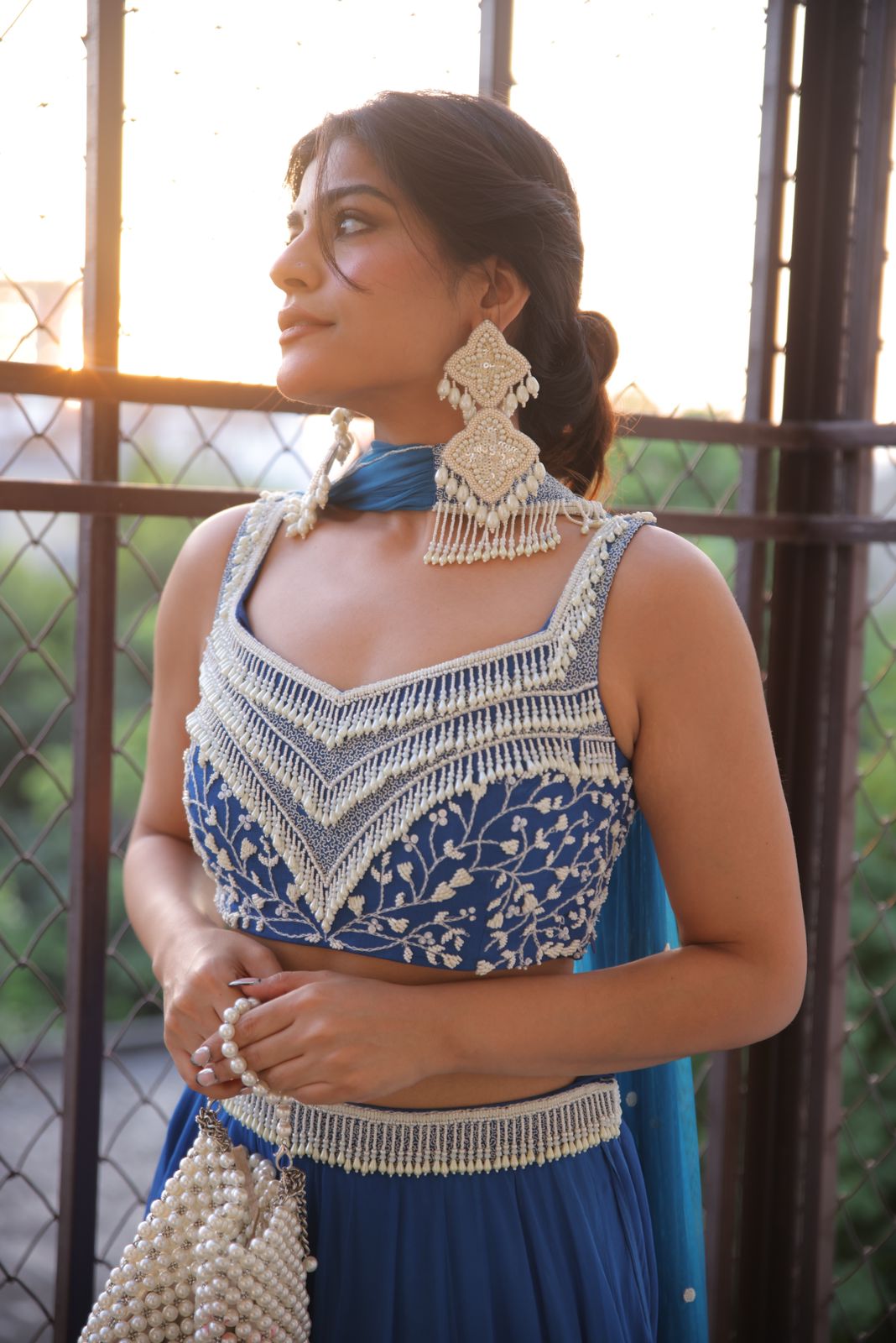 Kritika Khurana wearing a cobalt blue lehenga with pearl work and choker-style dupatta.