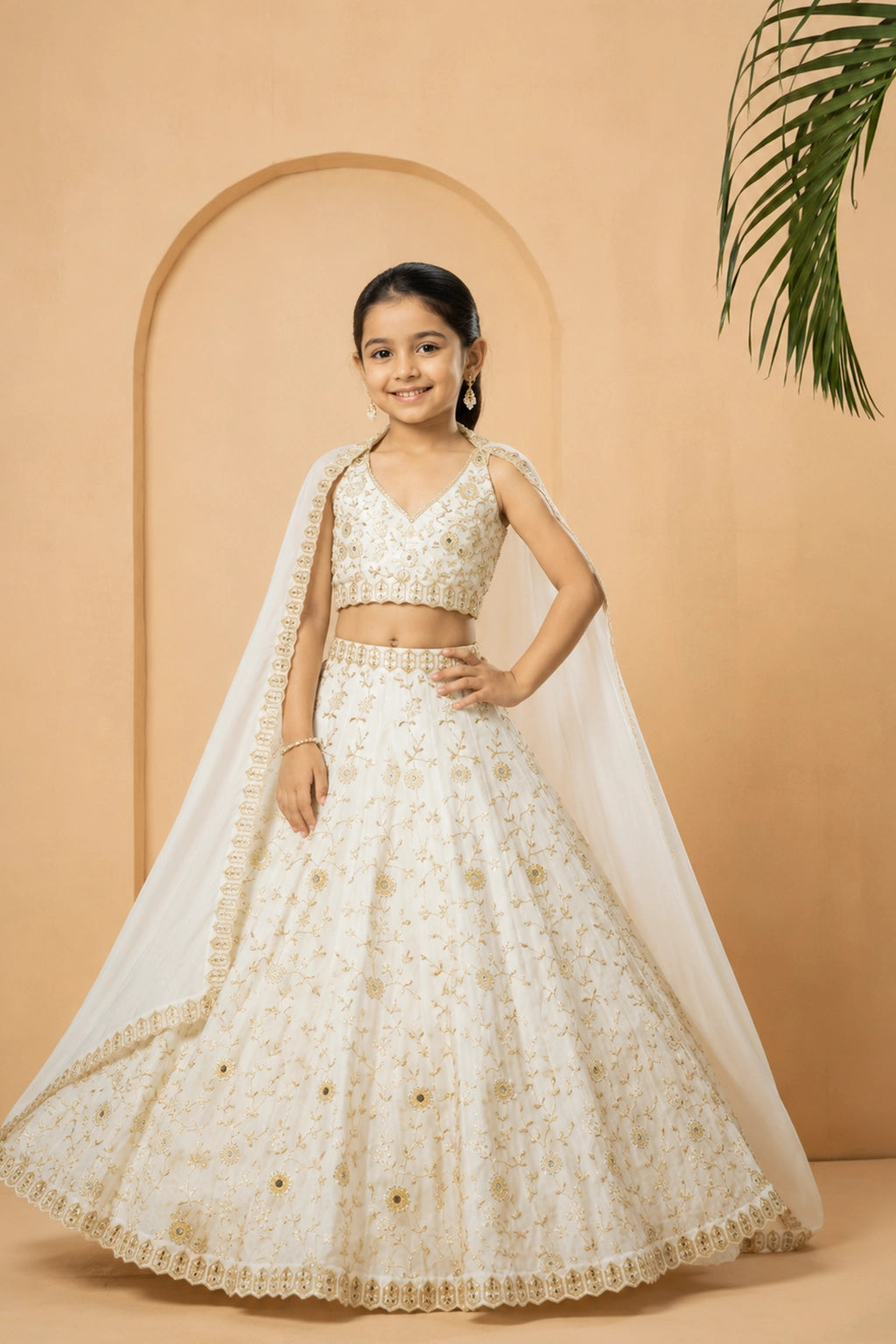 Ivory lehenga made from modal satin fabric, adorned with intricate mirror and pearl bead embellishments across the lehenga, blouse, and dupatta.