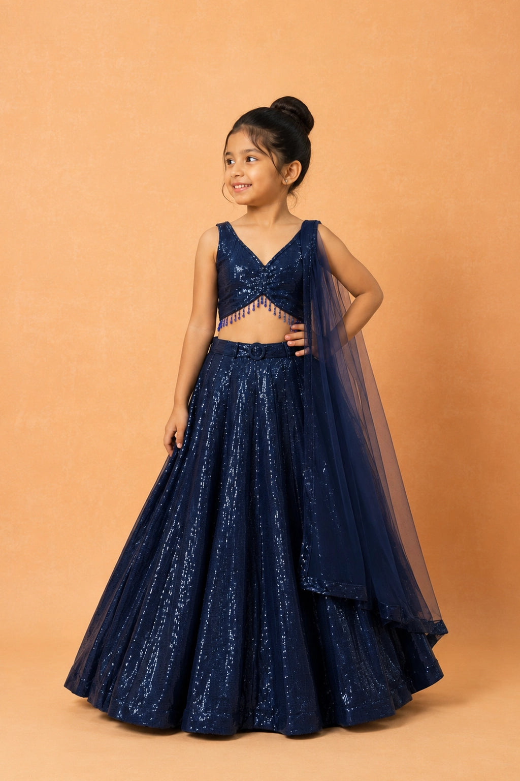 Deep blue georgette lehenga adorned with all-over sequins, lace detailing on the blouse, and a functional pocket. Paired with a matching soft net dupatta and waist belt.