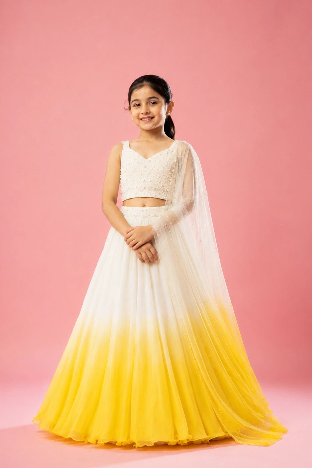 This ivory and sunshine yellow ombre lehenga in georgette is paired with a hand-embroidered blouse, belt, and soft net dupatta with pearl embellishments.