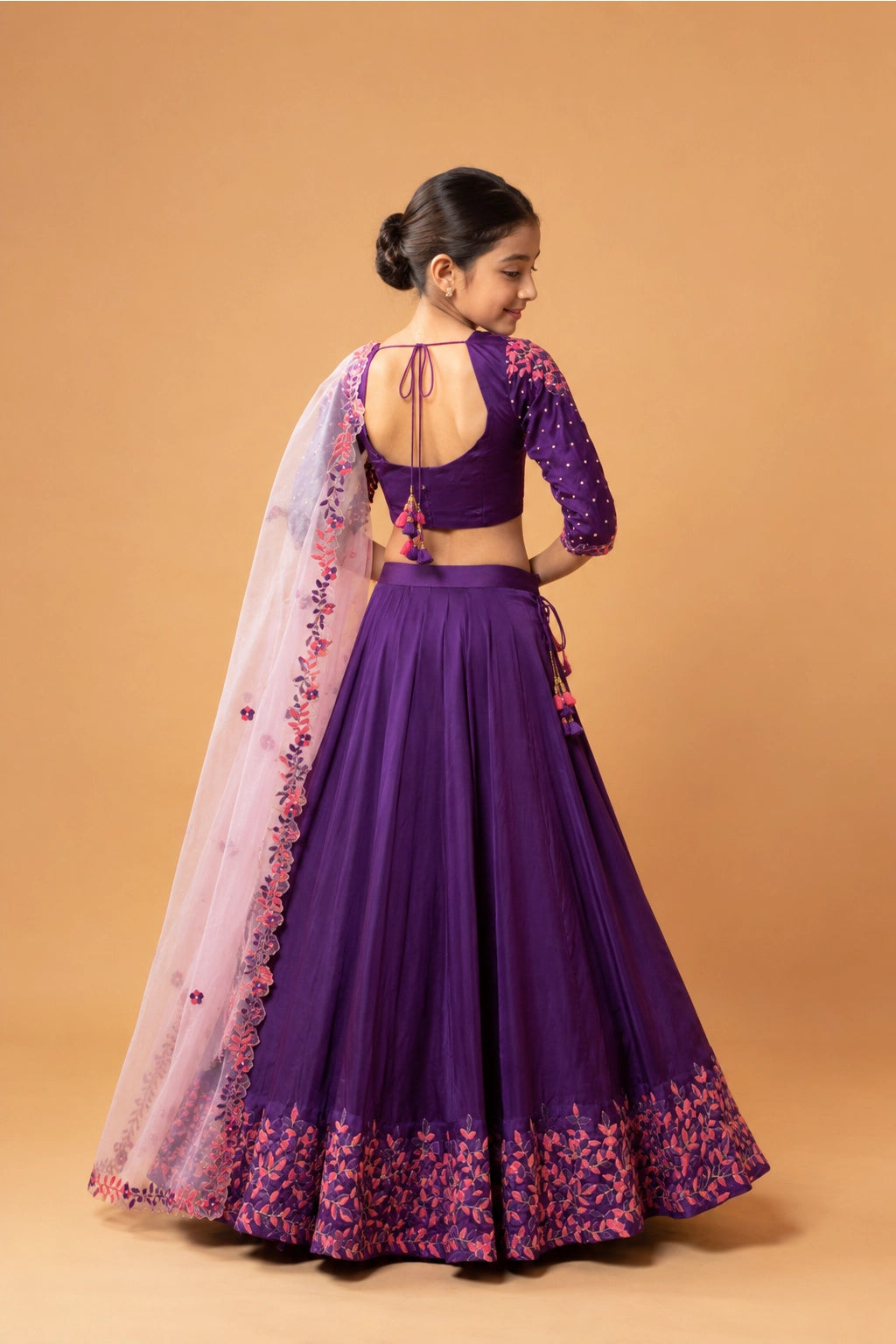 A violet lehenga made of modal fabric with intricate handwork on the blouse, lehenga, and dupatta. The dupatta is in contrasting baby pink.