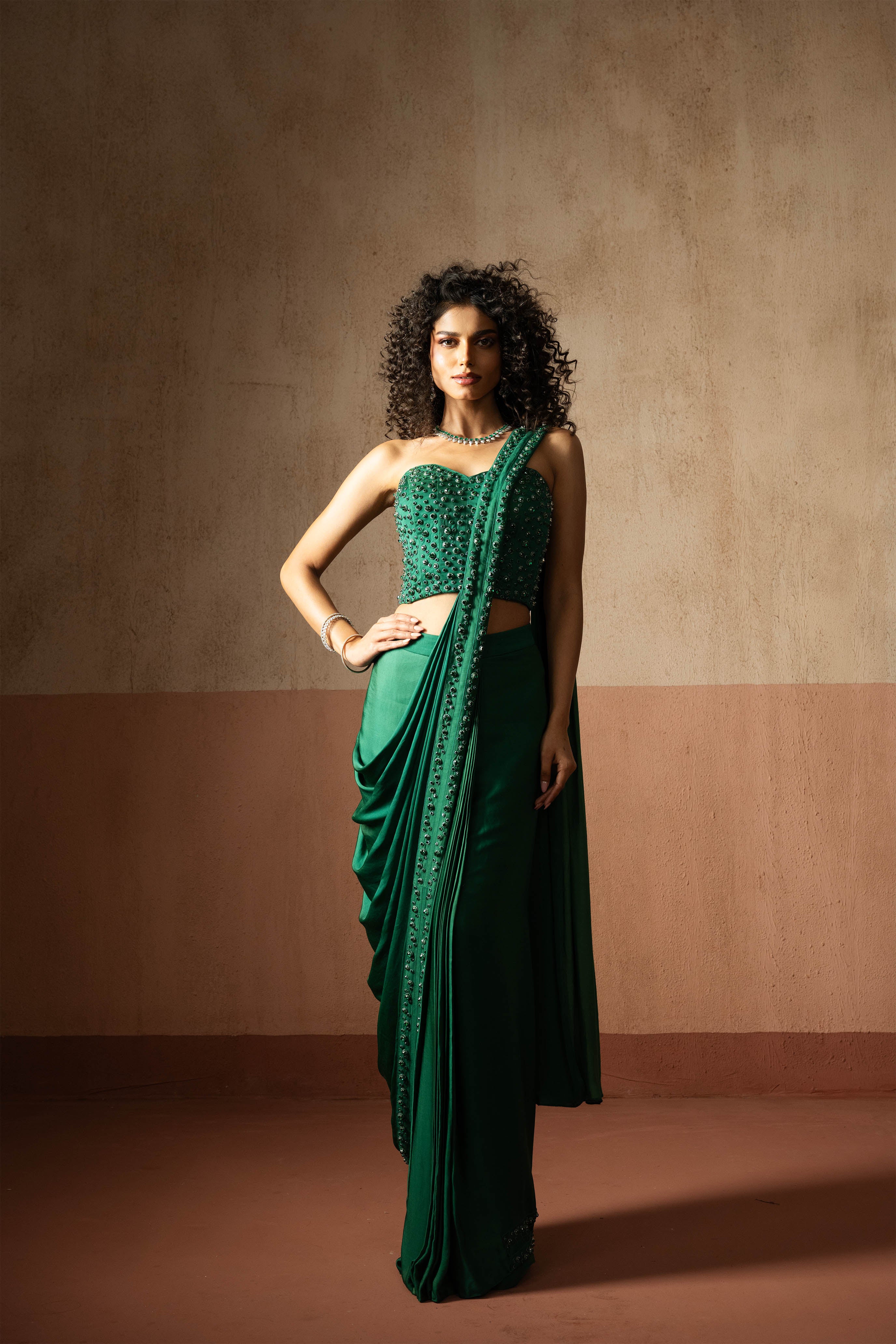 Predraped, emerald green hand embroidered satin saree with corset blouse