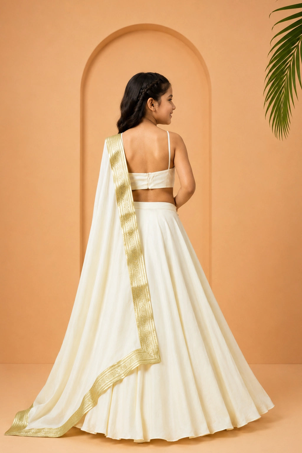An ivory modal satin lehenga with a sleeveless blouse and a dupatta accented with golden lace and latkan.