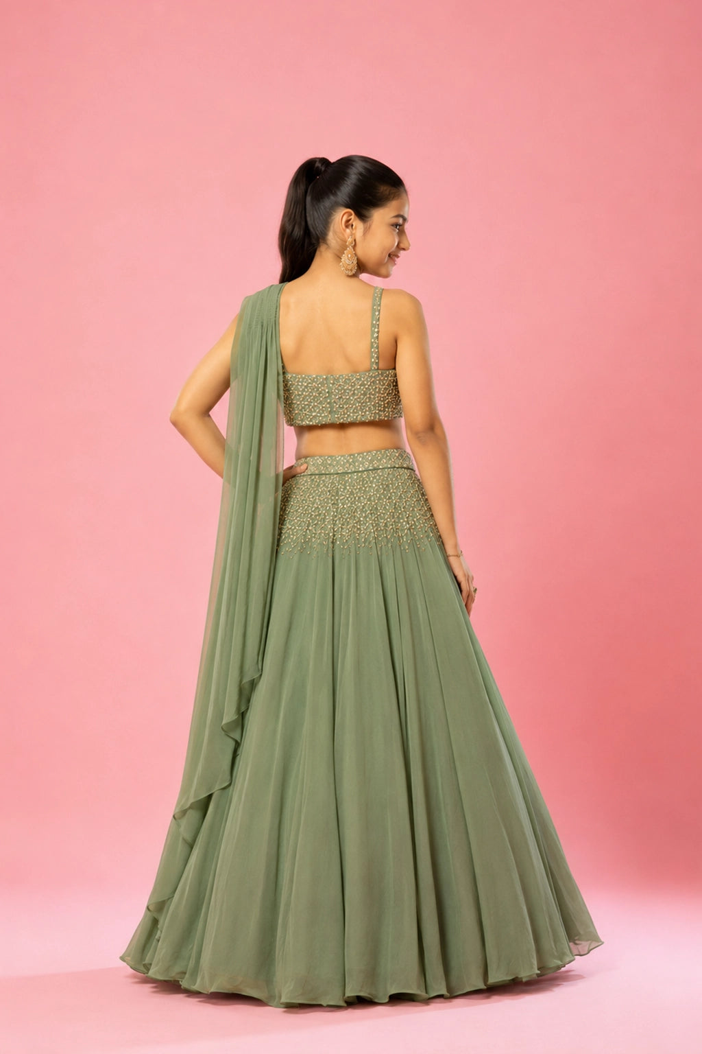 A graceful sage green drape lehenga in pure georgette, with intricate hand embroidery on the blouse and skirt.