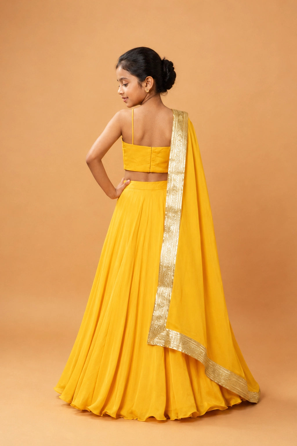 A bright yellow lehenga in modal fabric with a sleeveless blouse. The dupatta is finished with a golden zari border.