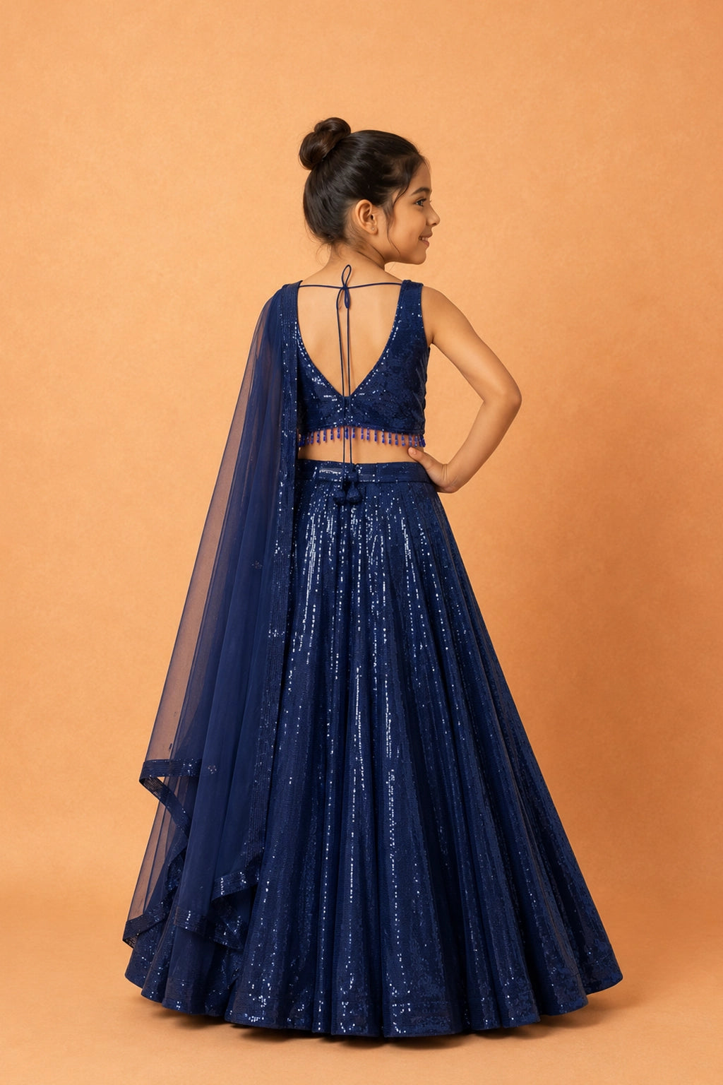Deep blue georgette lehenga adorned with all-over sequins, lace detailing on the blouse, and a functional pocket. Paired with a matching soft net dupatta and waist belt.