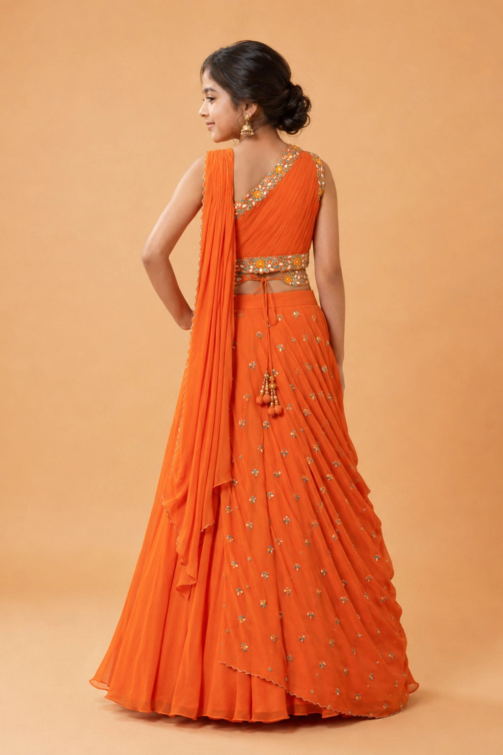 Orange georgette draped lehenga, with hand embroidery. Paired with a matching hand-embroidered belt.