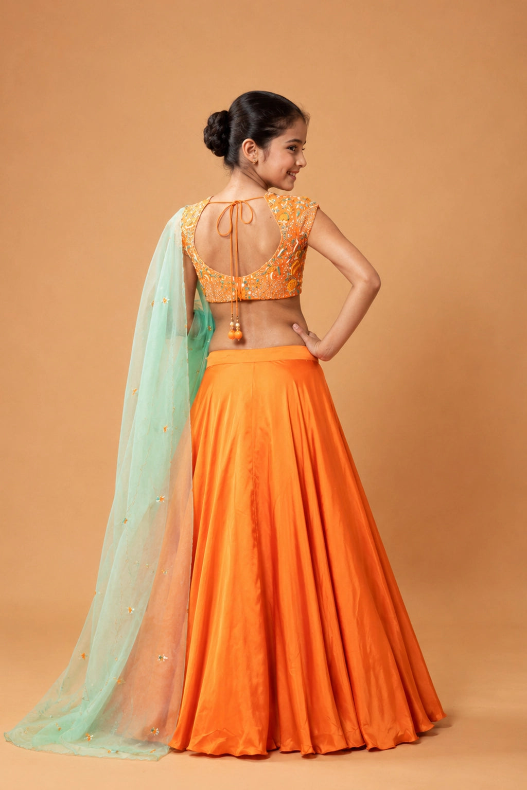 Orange lehenga in modal fabric with intricate handwork on the blouse and dupatta, including kardana, moti, stones, and zari.