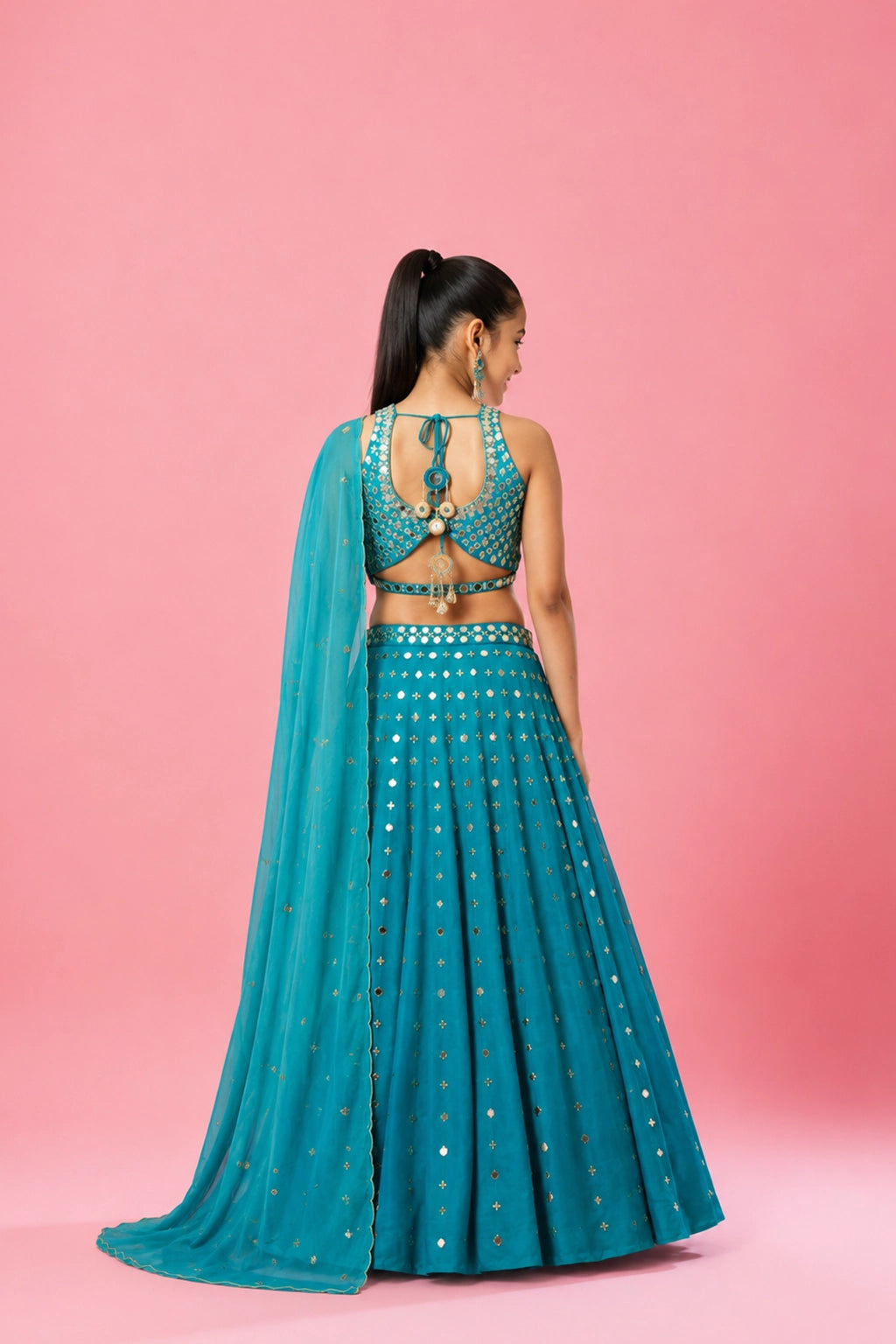 Turquoise lehenga in modal satin fabric, embellished with intricate mirror and pearl beadwork. Paired with a matching blouse and dupatta for a perfect festive look.