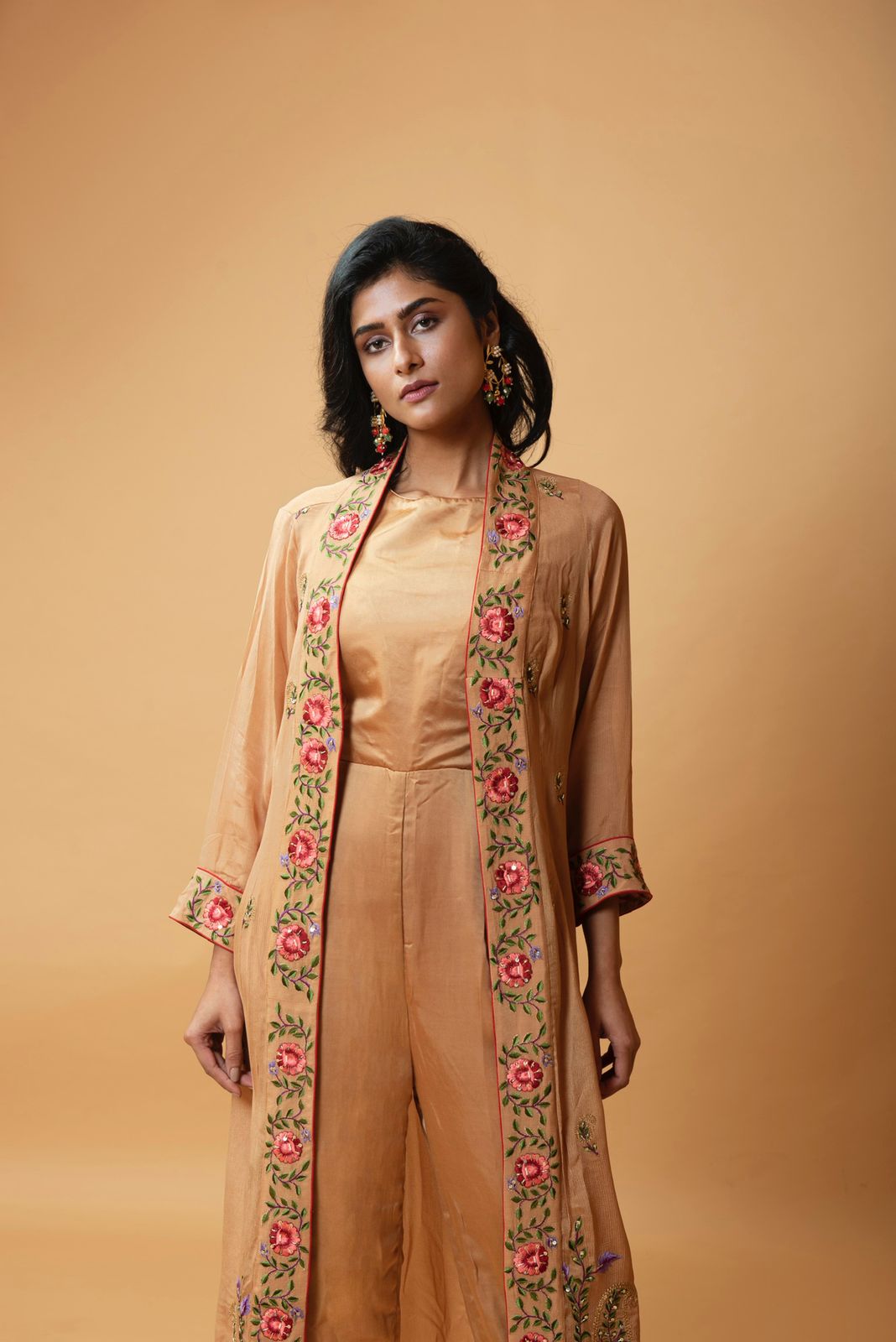Light bronze jumpsuit with an embroidered jacket featuring floral motifs.
