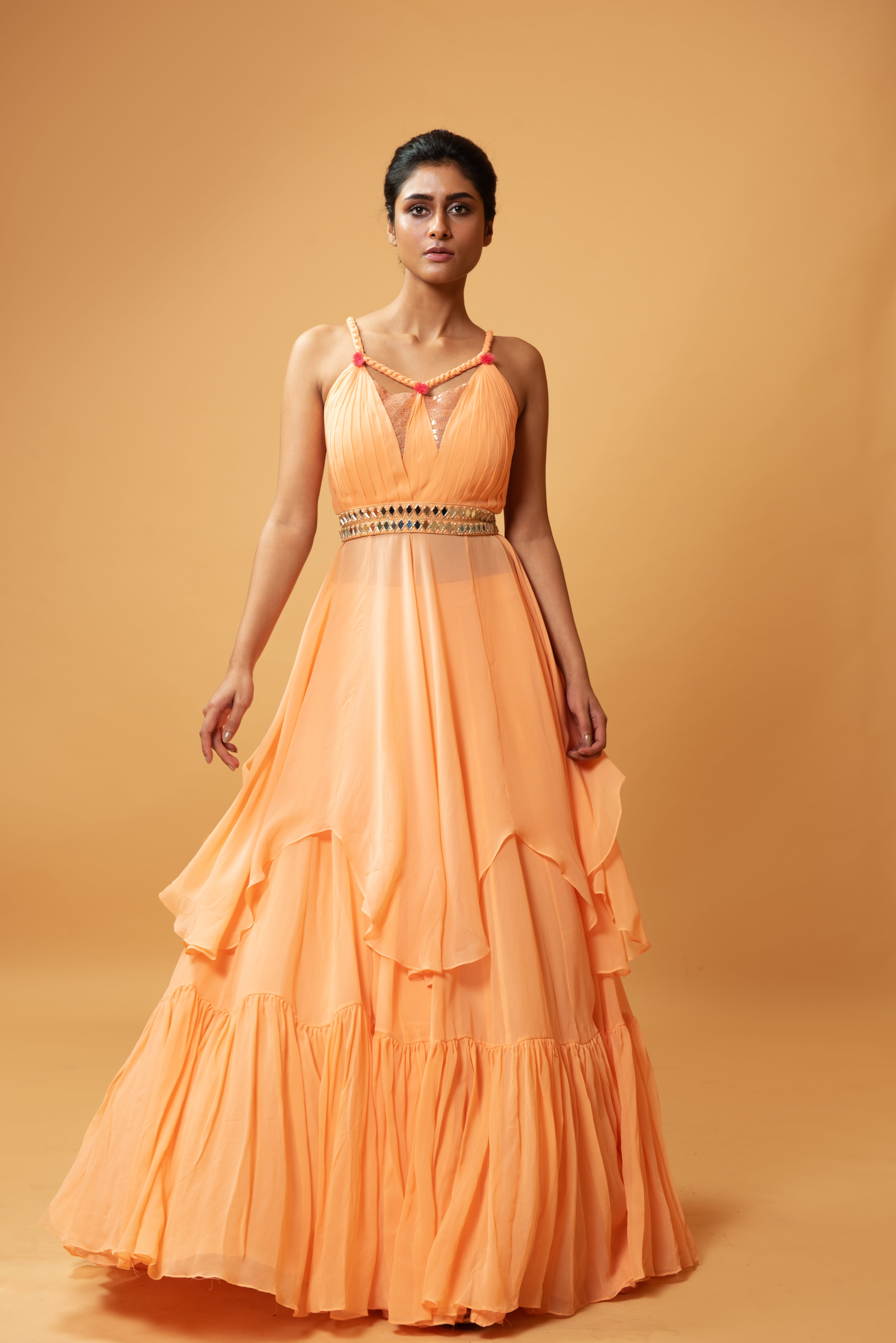 Peach sleeveless co-ord set with sequins, ruffled lehenga, and mirror-embellished waist belt.