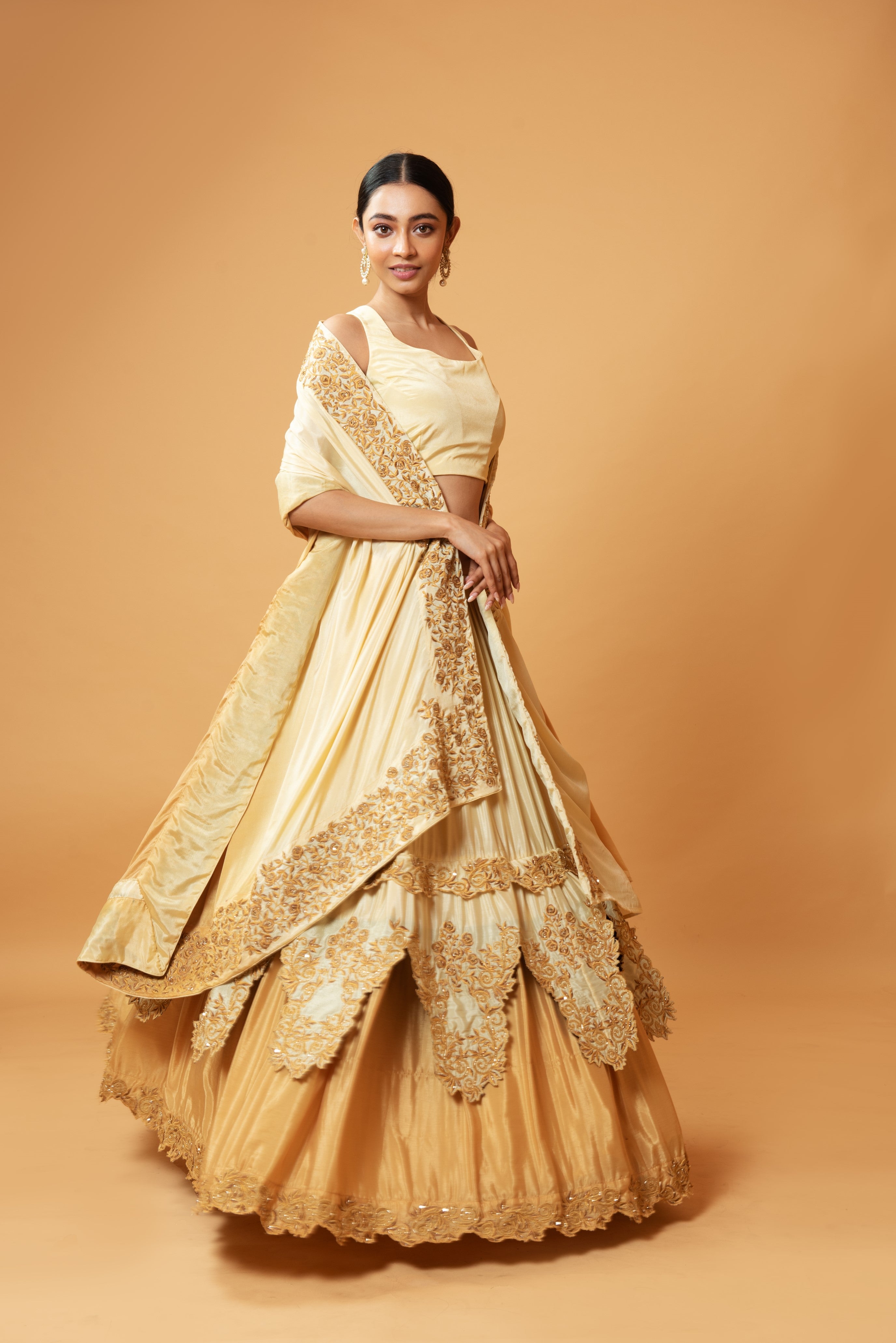 Golden ombre lehenga with floral embroidery and layered design.