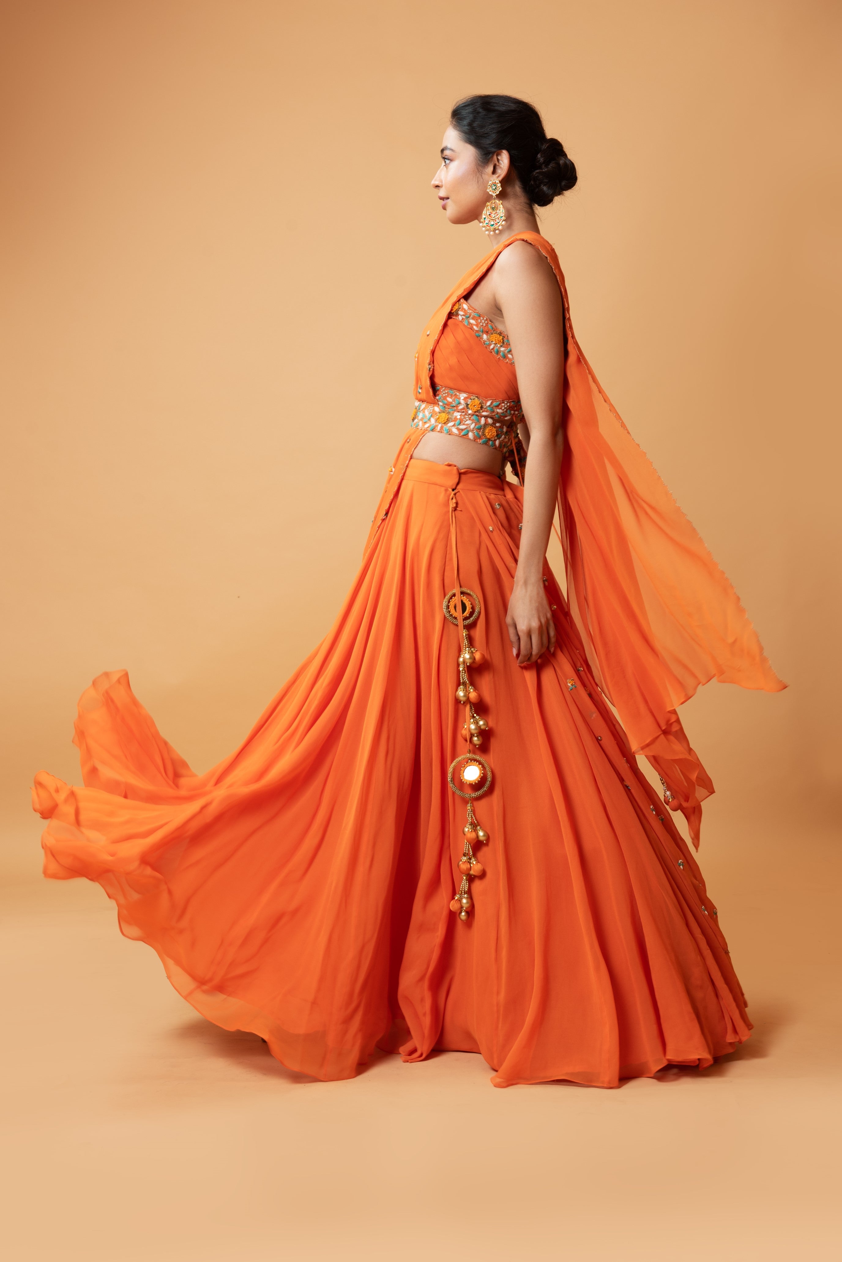 Bright orange draped lehenga with a matching embroidered belt.