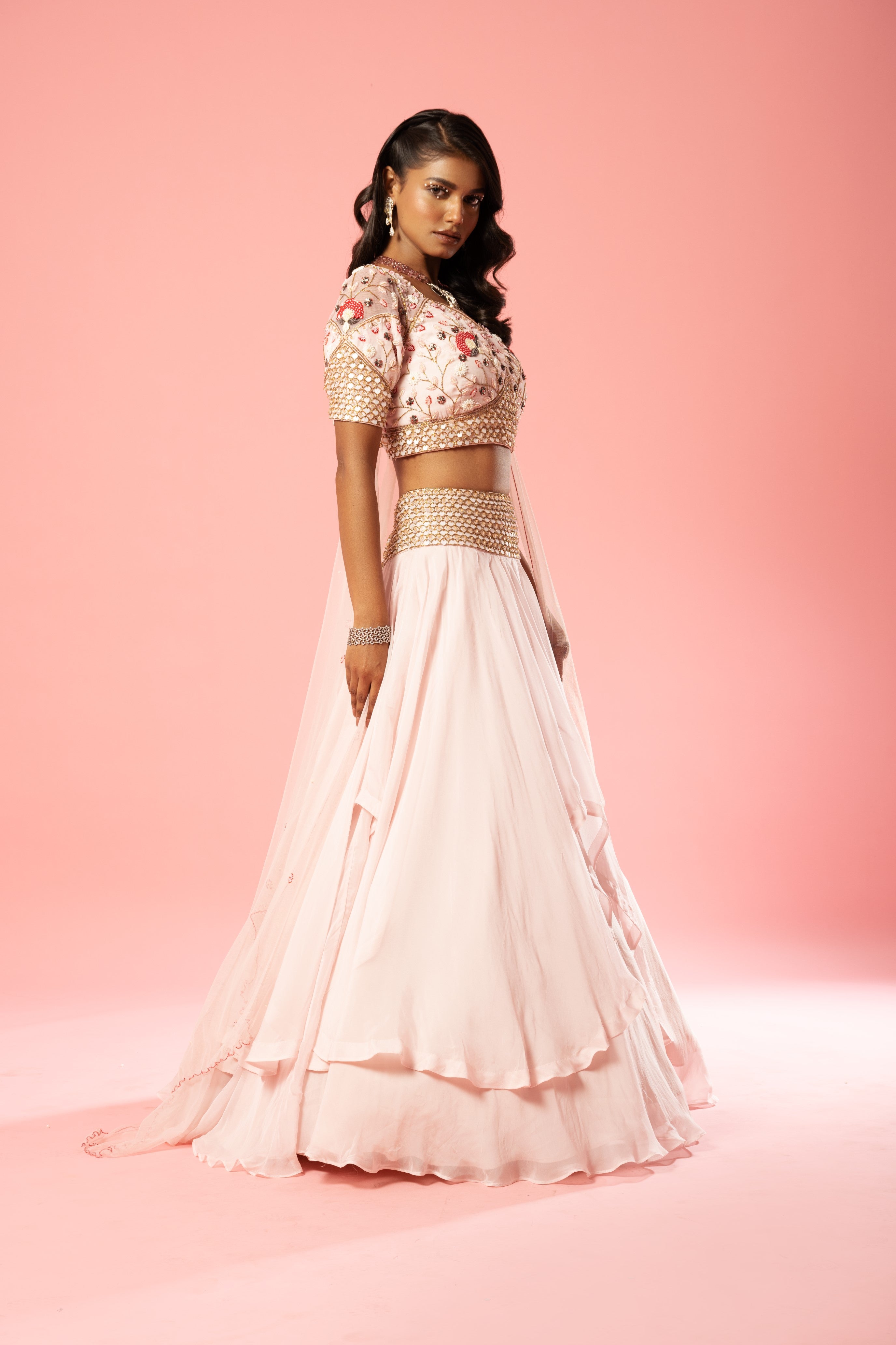 Baby pink organza lehenga with hand-embroidered blouse, belt, and net dupatta.