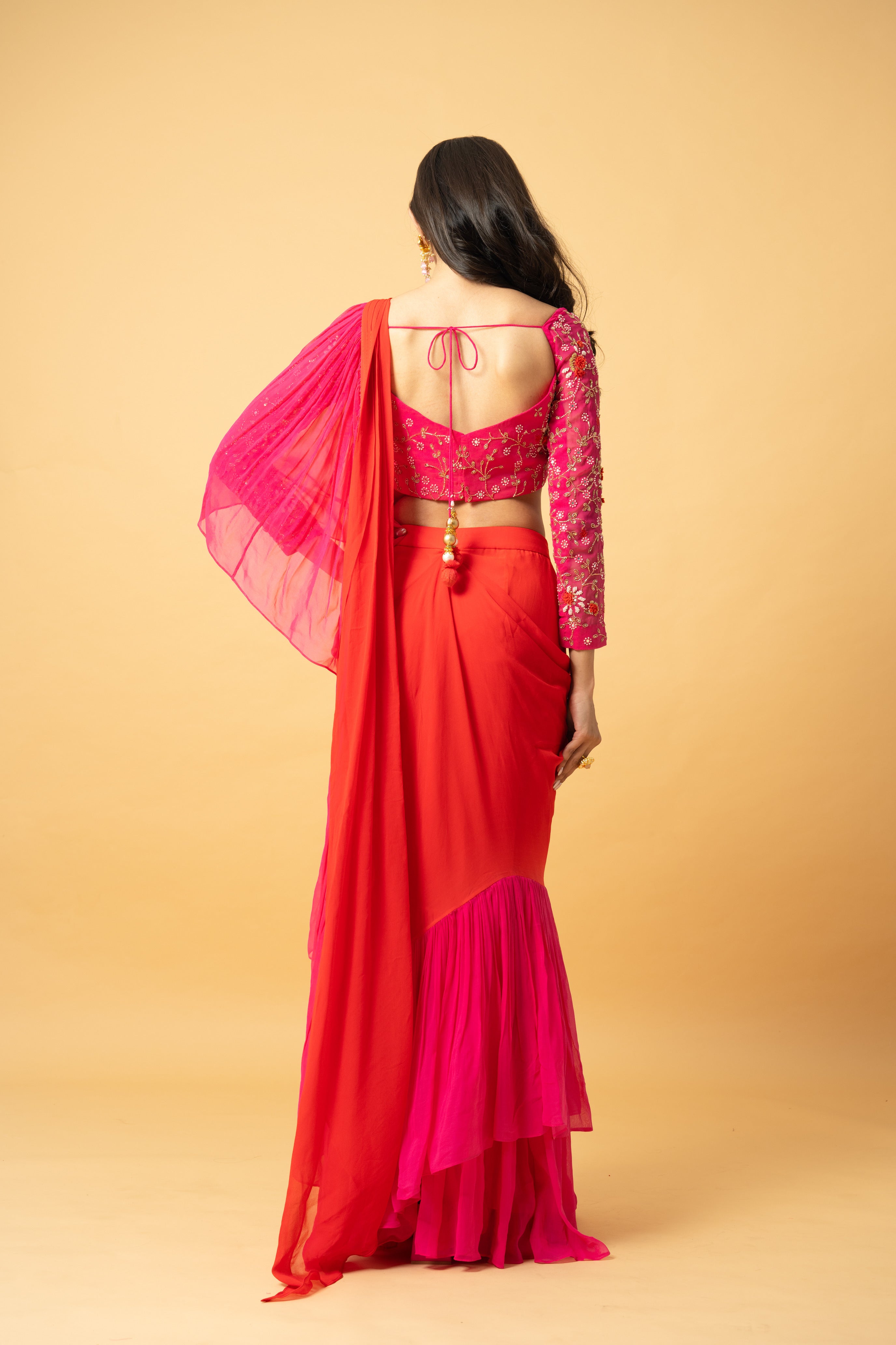 Pink and orange georgette ruffle saree with hand-embroidered full-sleeve blouse.