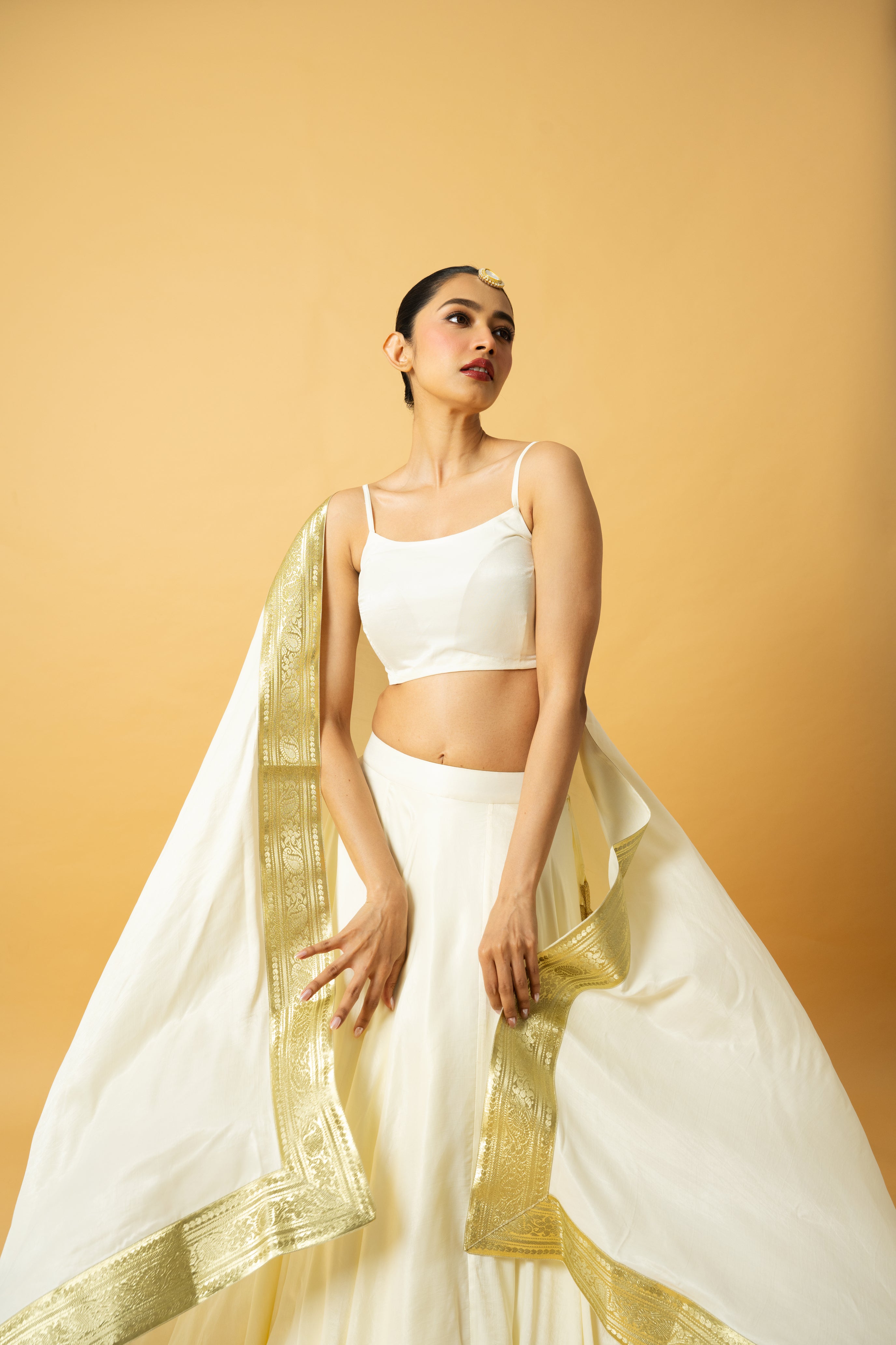 Ivory modal satin lehenga with a golden lace dupatta and latkan details.